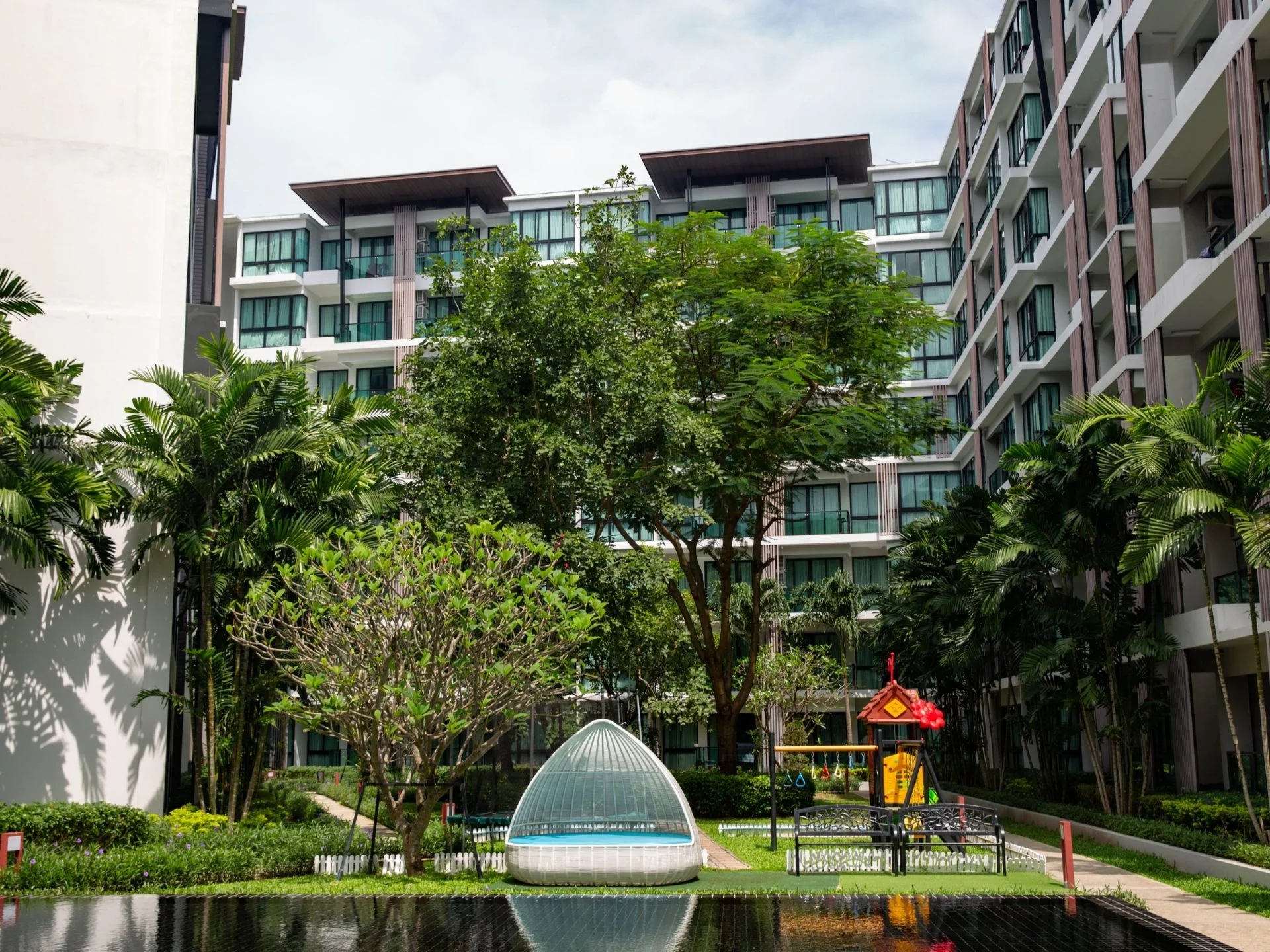 Angelegter Innenhof mit Kinderspielplatz im Royal Lee The Terminal Phuket, Thailand