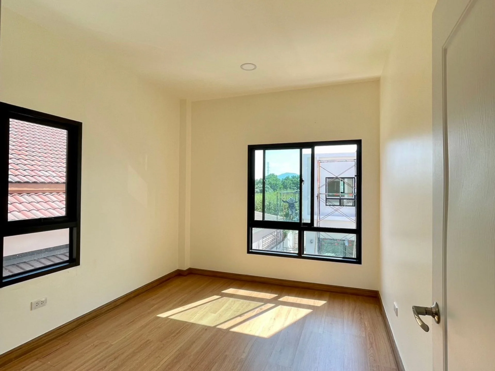 Interior de dormitorio con piso de madera y vista a las montañas en NAI HOME Srisunthon 2, Tailandia