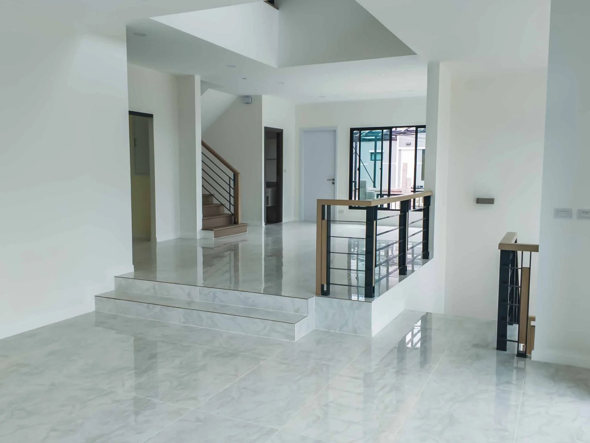 Open-plan living area with staircase and mezzanine in villa at The Palm Kathu-Patong, Thailand