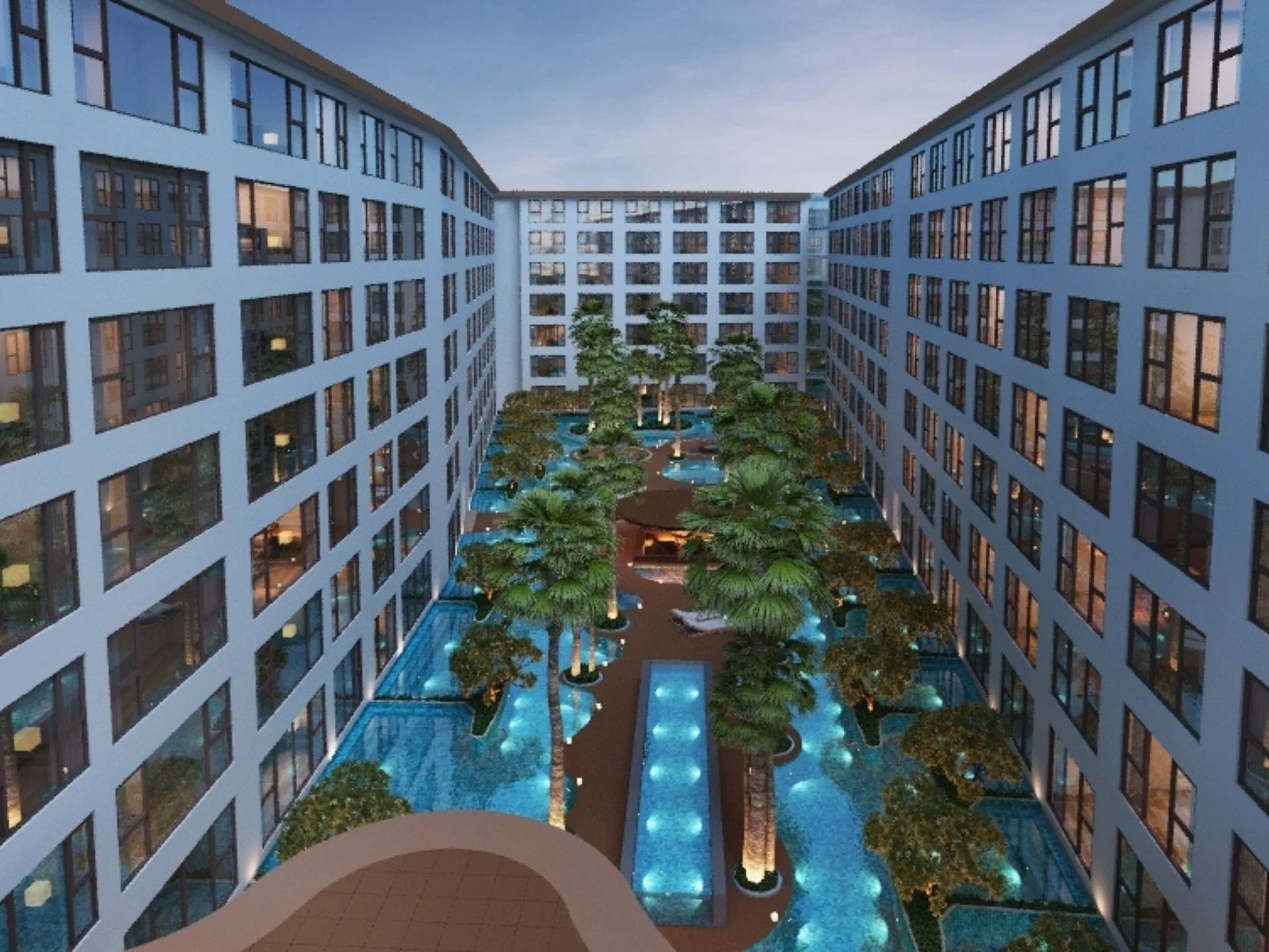 Central courtyard with illuminated water features and landscaping at Capri Residence, Thailand