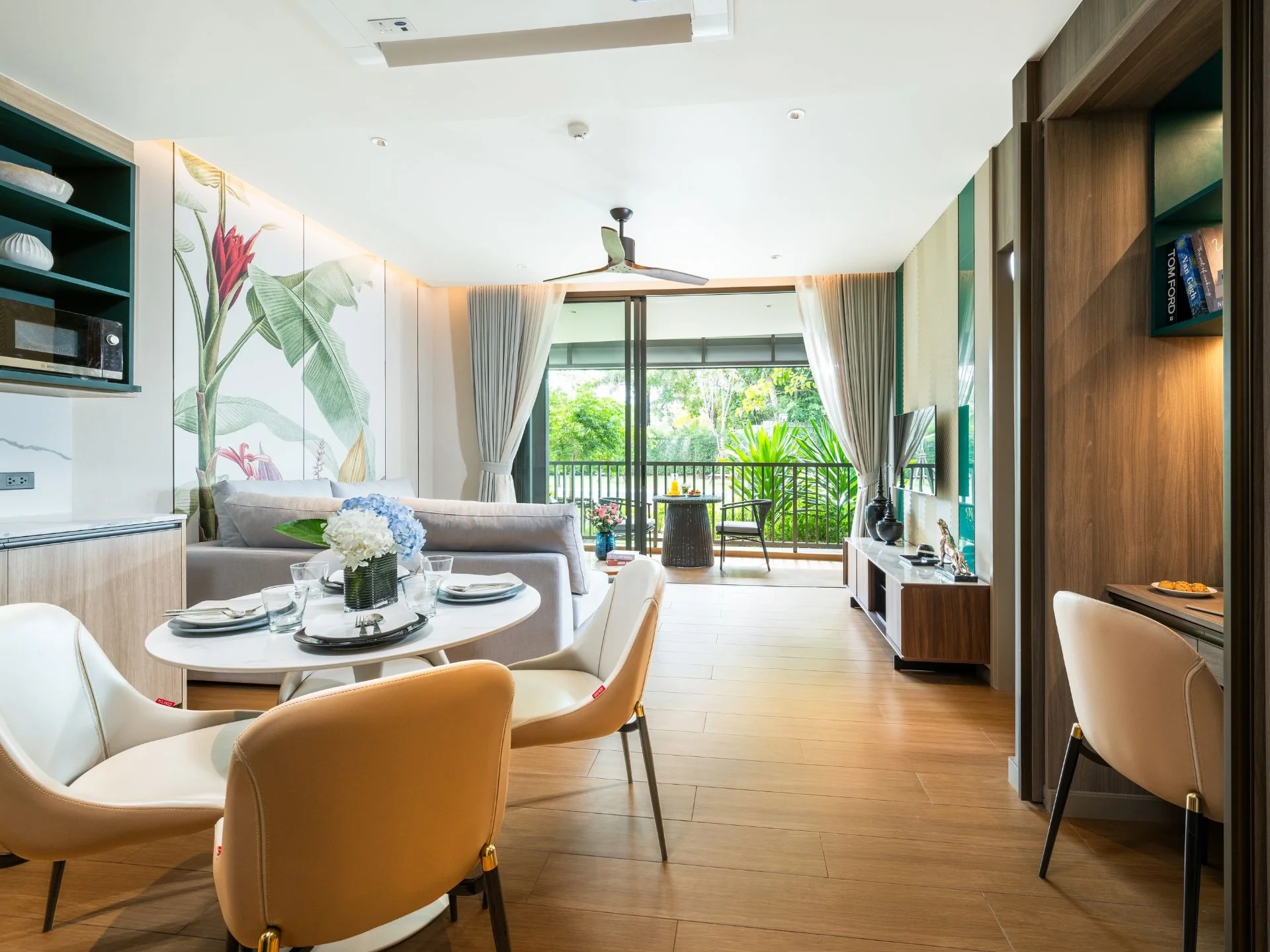 Open-plan living and dining area with garden view in 1-bedroom apartment at Laguna Skypark Elara, Bang Tao