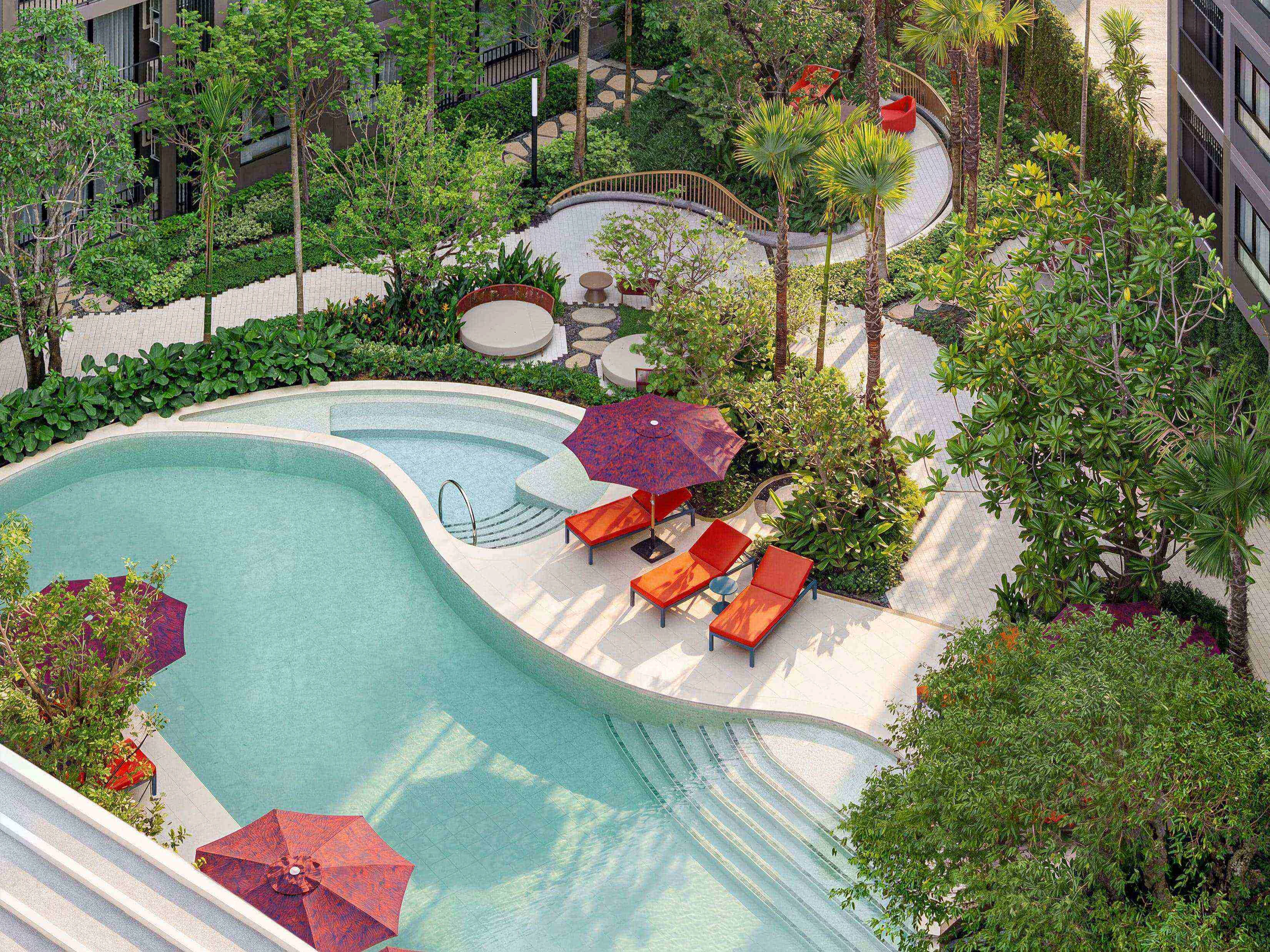 Landscaped swimming pool area with loungers at The Base Cherngtalay, Chengthalay