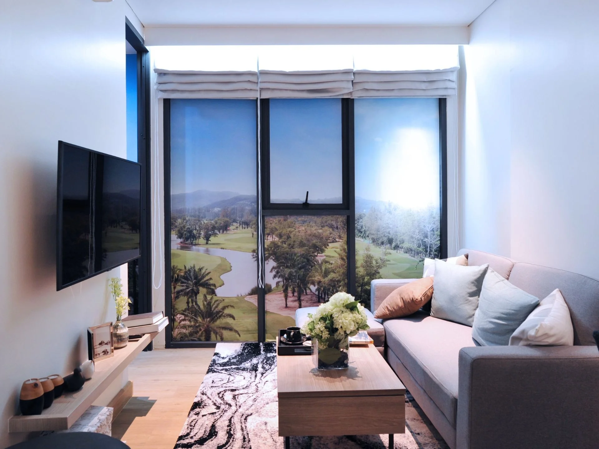 Living room with golf course and mountain view in 1-bedroom apartment at Laguna Skypark Celeste, Bang Tao