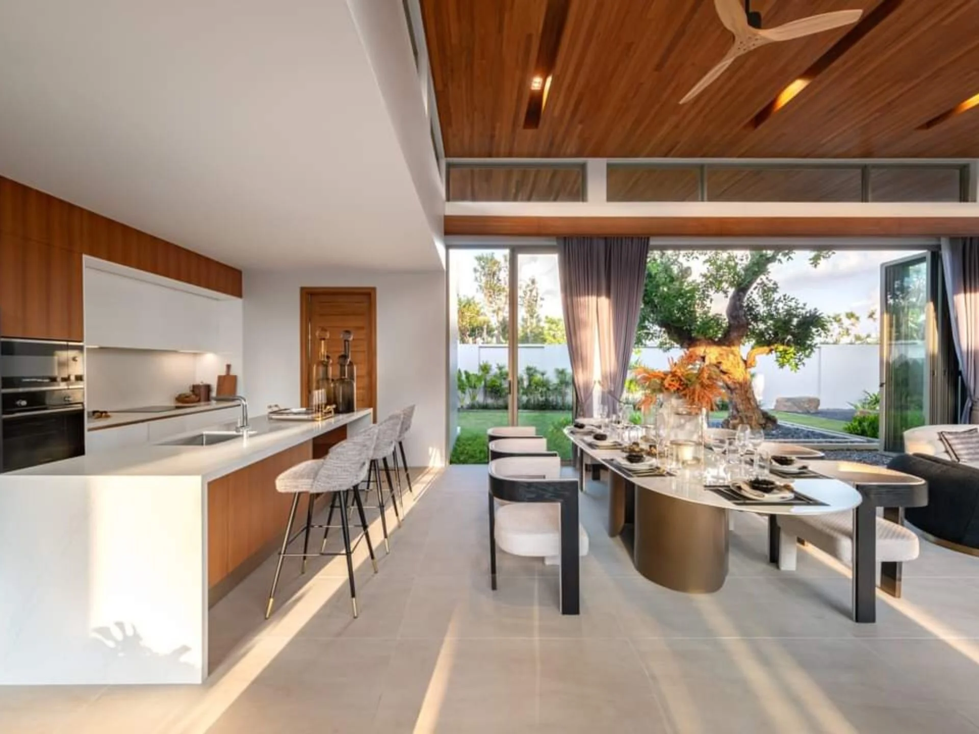 Open-plan kitchen and dining area with garden view in 3-bedroom villa at Botanica Grand Avenue, Chiang Rai