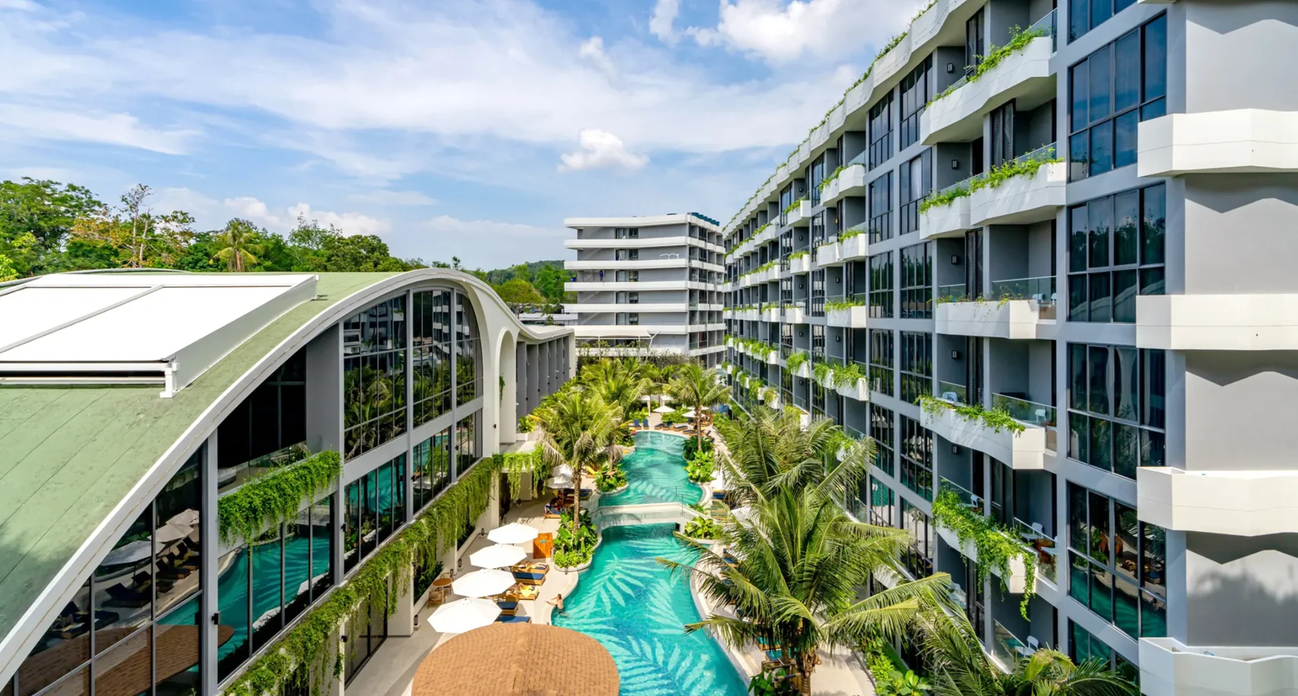 Swimmingpool-Bereich mit Palmen und Wohnanlagen im Layan Green Park Phase 1, Layan, Thailand