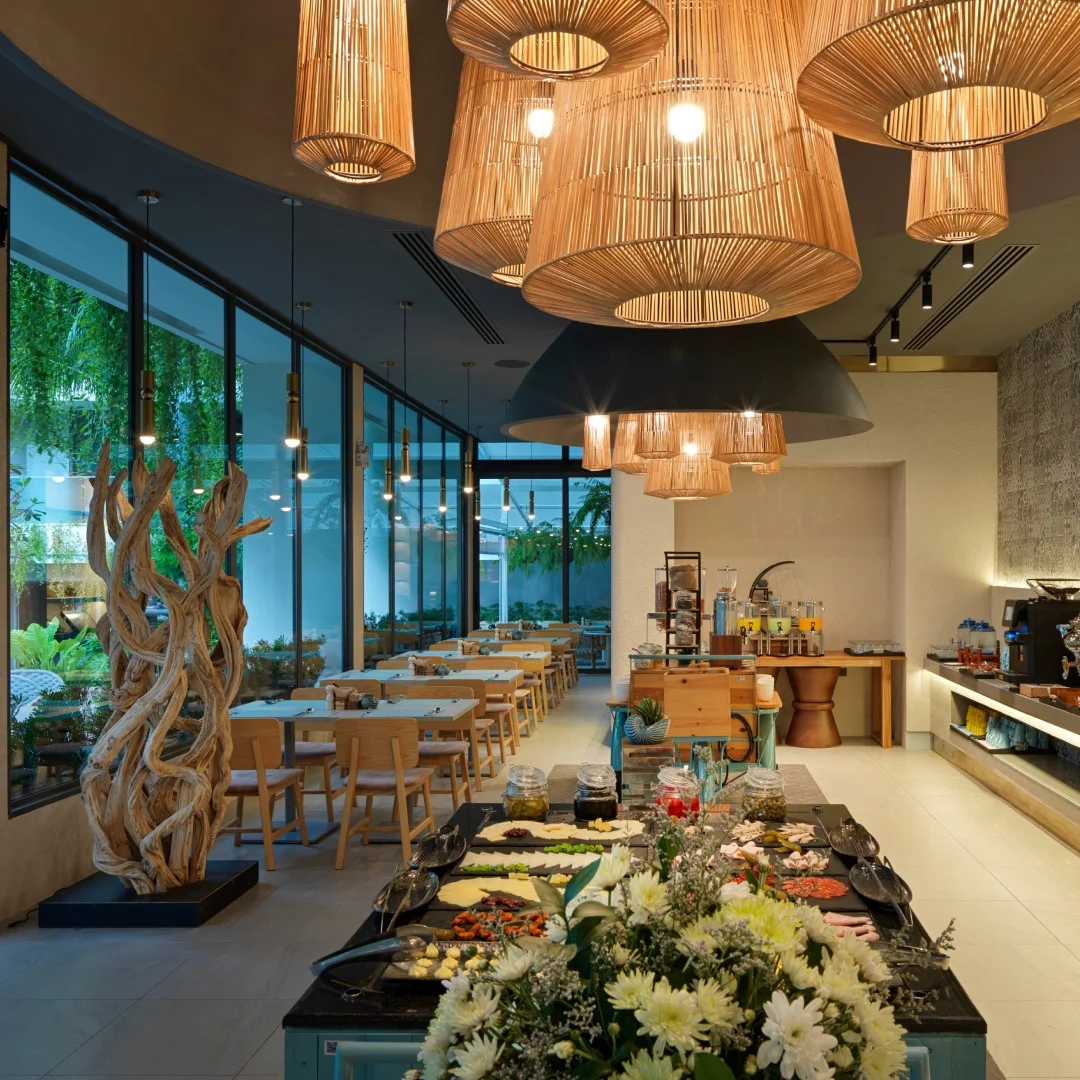 Restaurant interior with wicker pendant lamps and buffet counter at Layan Green Park Phase 1, Thailand