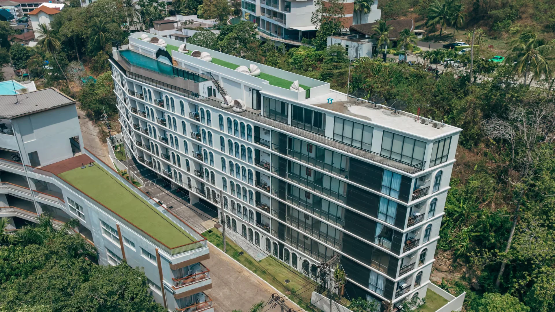 Aerial view of Palmetto Park residence building with rooftop pool and green terrace, Karon, Thailand