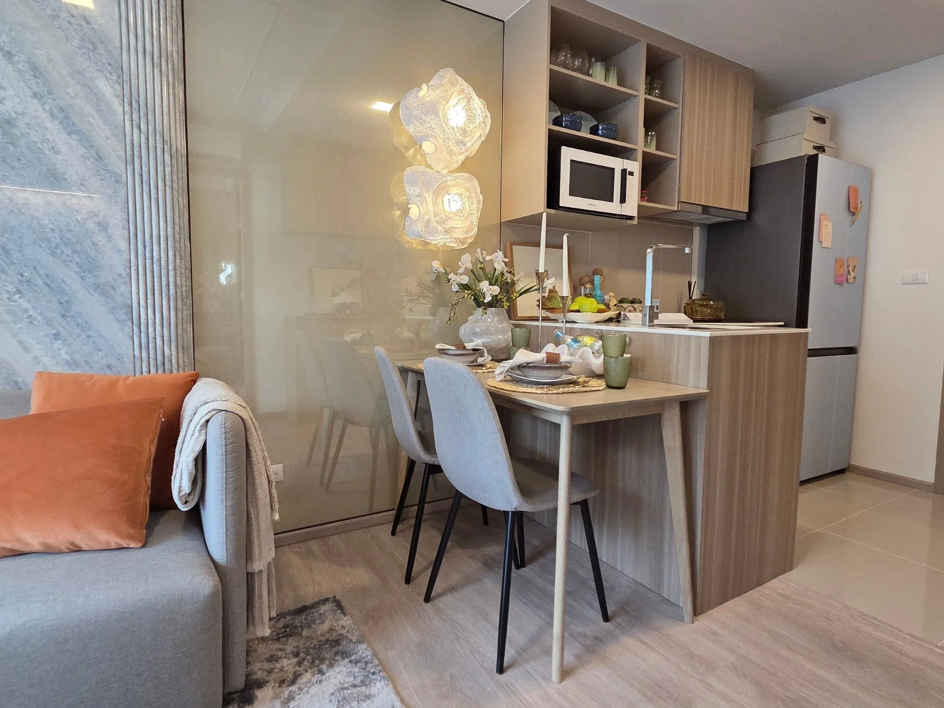 Dining area and open kitchen interior in a 2-bedroom apartment at Rhea, Surin, Thailand