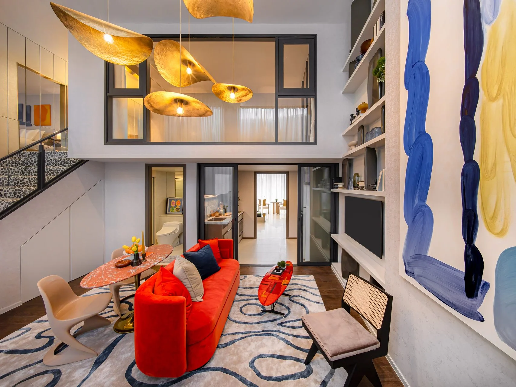Living room with red sofa and brass pendant lamps in a 1-bedroom loft at SHUSH Ratchathewi, Thailand