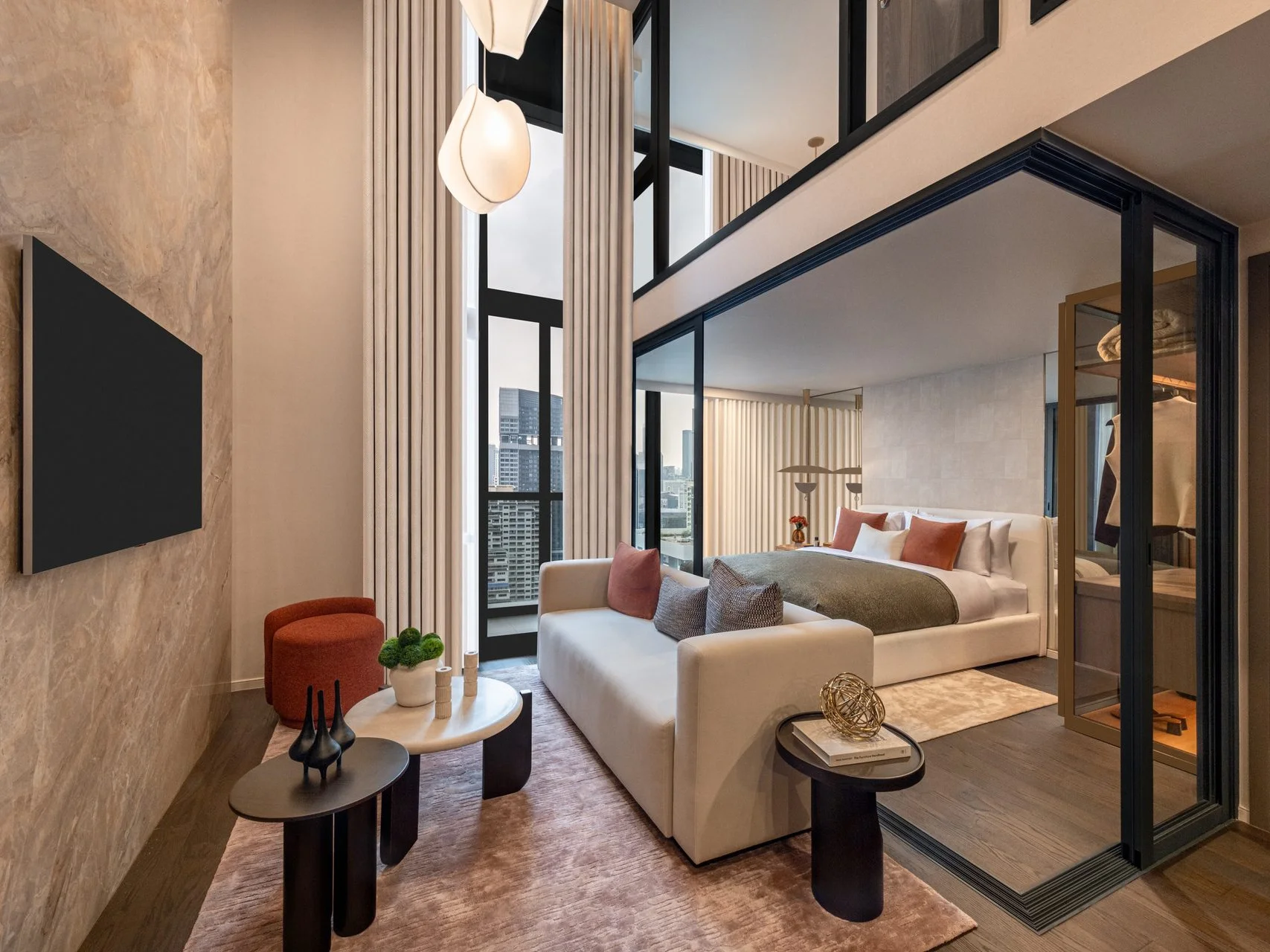 Living room interior with sofa, bedroom and double-height windows in a 2-bedroom loft at SHUSH Ratchathewi, Thailand