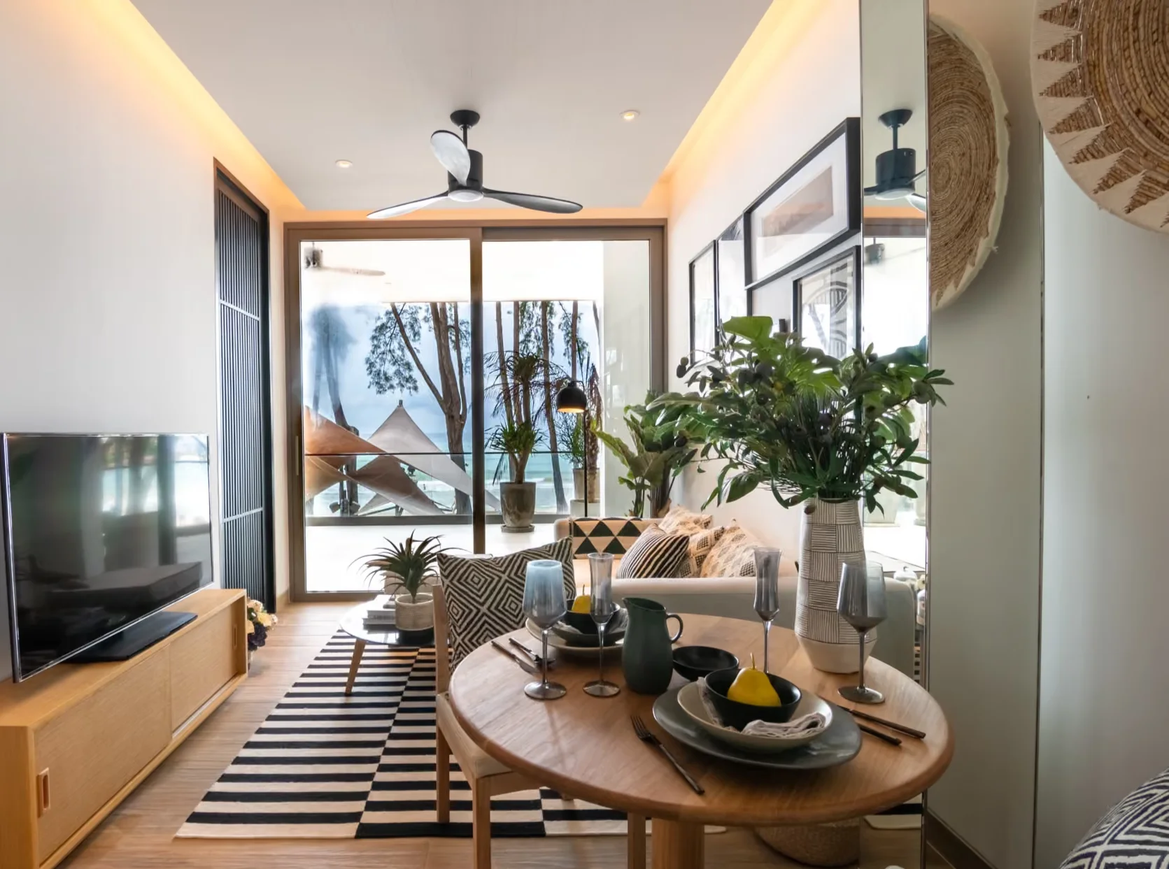 Living room and dining area with sea view in a 1-bedroom apartment at MGallery Residences MontAzure, Kamala, Thailand