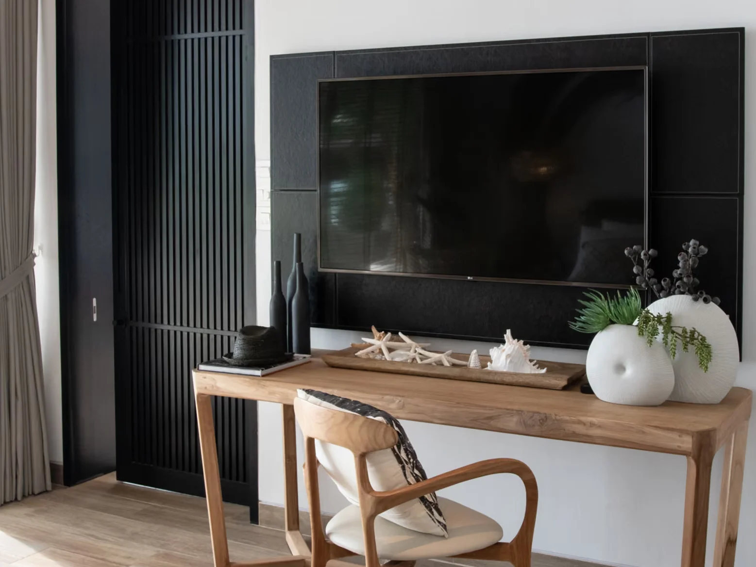 Living area interior with wall-mounted TV and teak console desk in a studio at MGallery Residences MontAzure, Kamala, Thai...