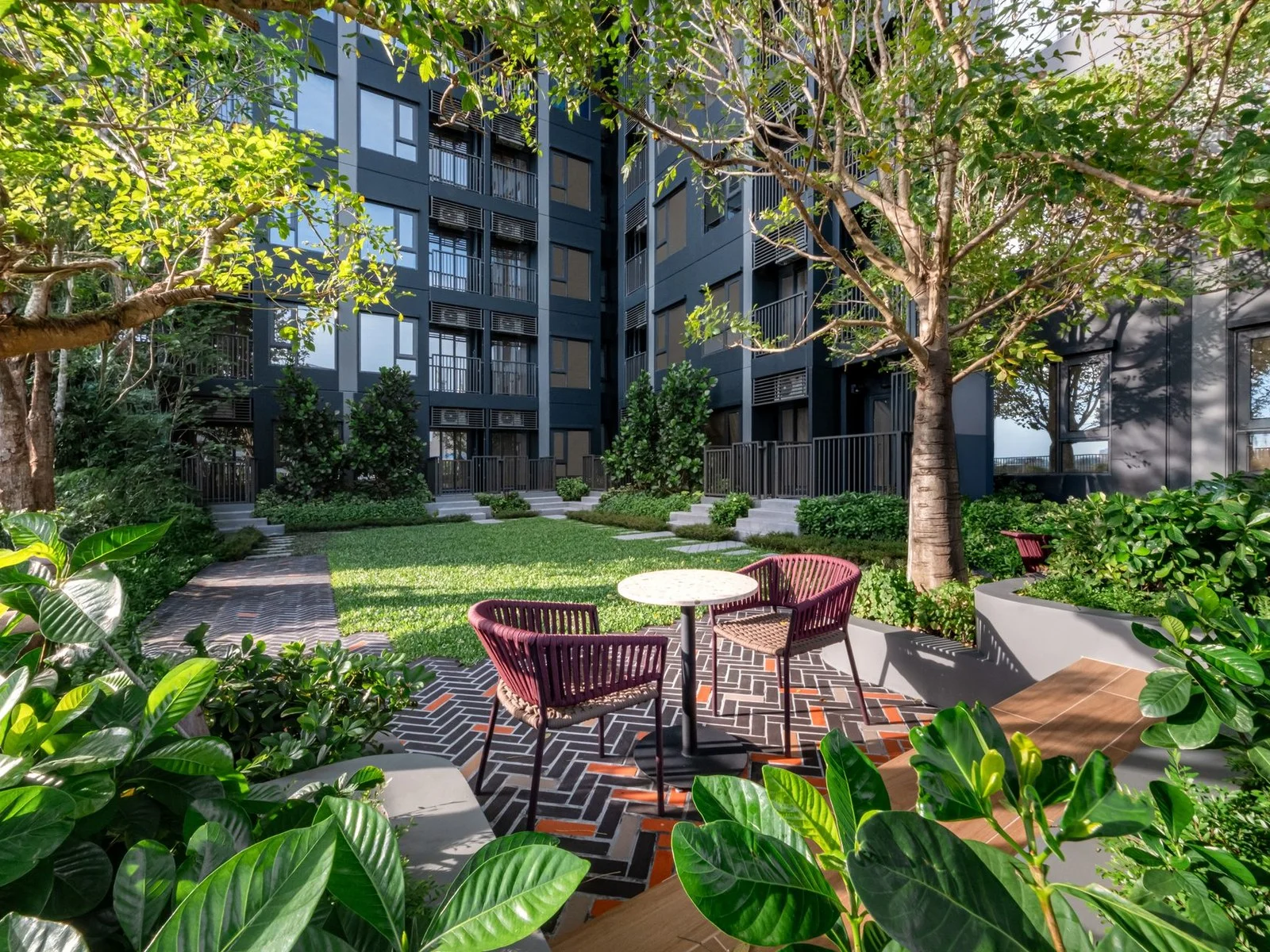 Landscaped courtyard with lawn and outdoor seating at FLO by Sansiri, Khlong San, Thailand