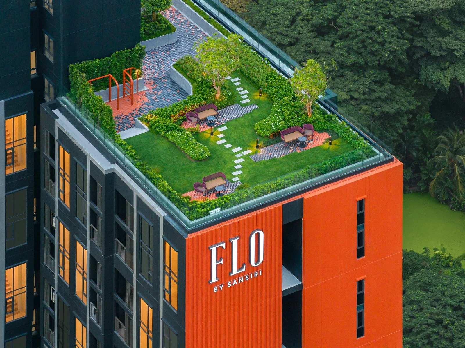 Rooftop garden terrace with lounge seating and orange exercise equipment at FLO by Sansiri, Khlong San, Thailand