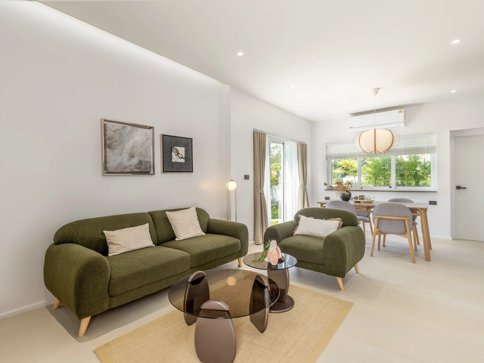 Living room with green sofa and dining area in a 3-bedroom townhouse at MIDORI, Central Phuket, Thailand